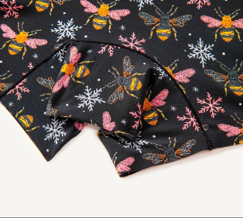 Close-up of PureSnug biker shorts panel with colorful bee & snowflake designs and black trim detailing.