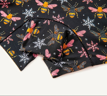 Close-up of PureSnug biker shorts panel with colorful bee & snowflake designs and black trim detailing.