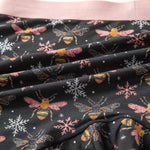 Fabric with bee and snowflake pattern on black background