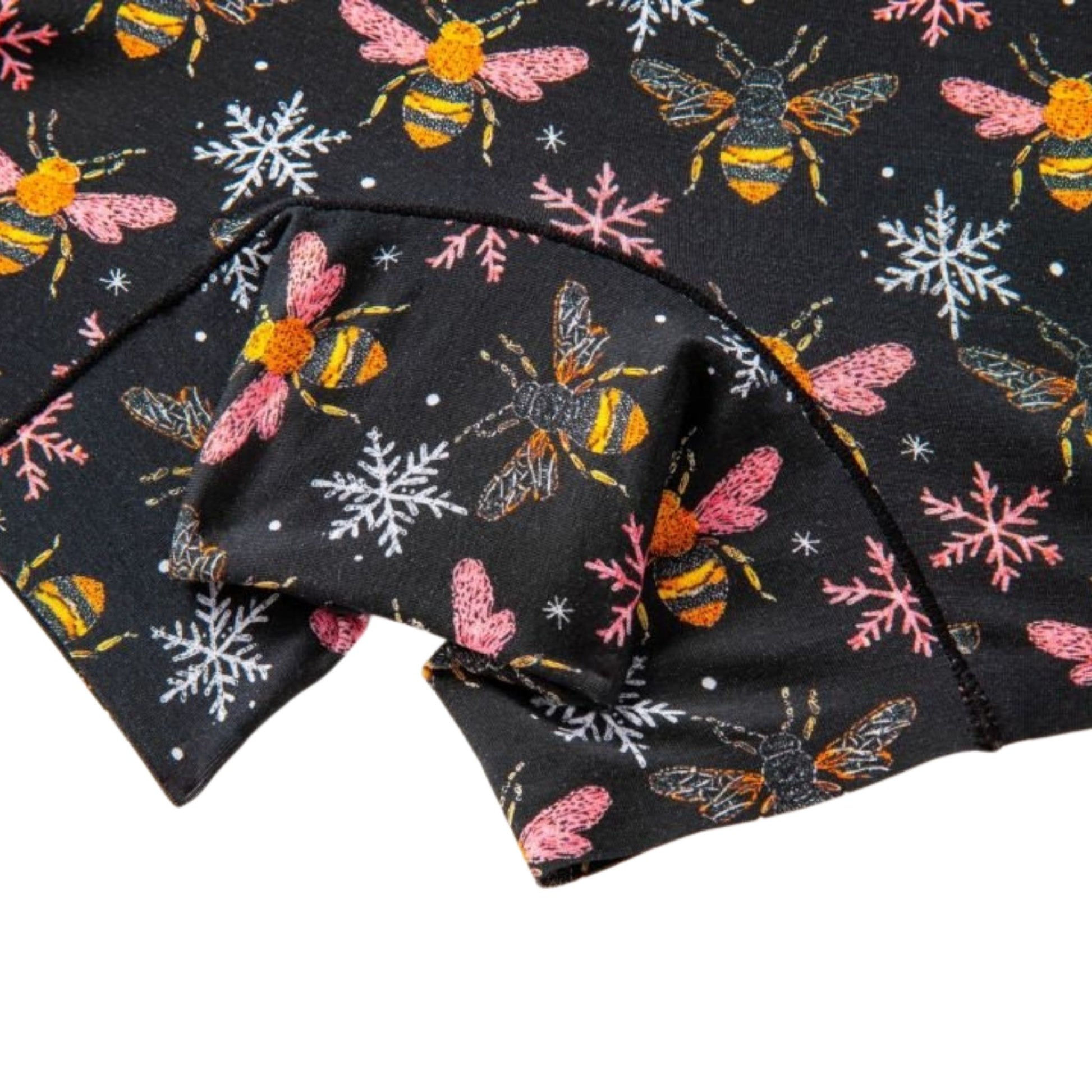 Folded fabric with bee and snowflake pattern on a black background