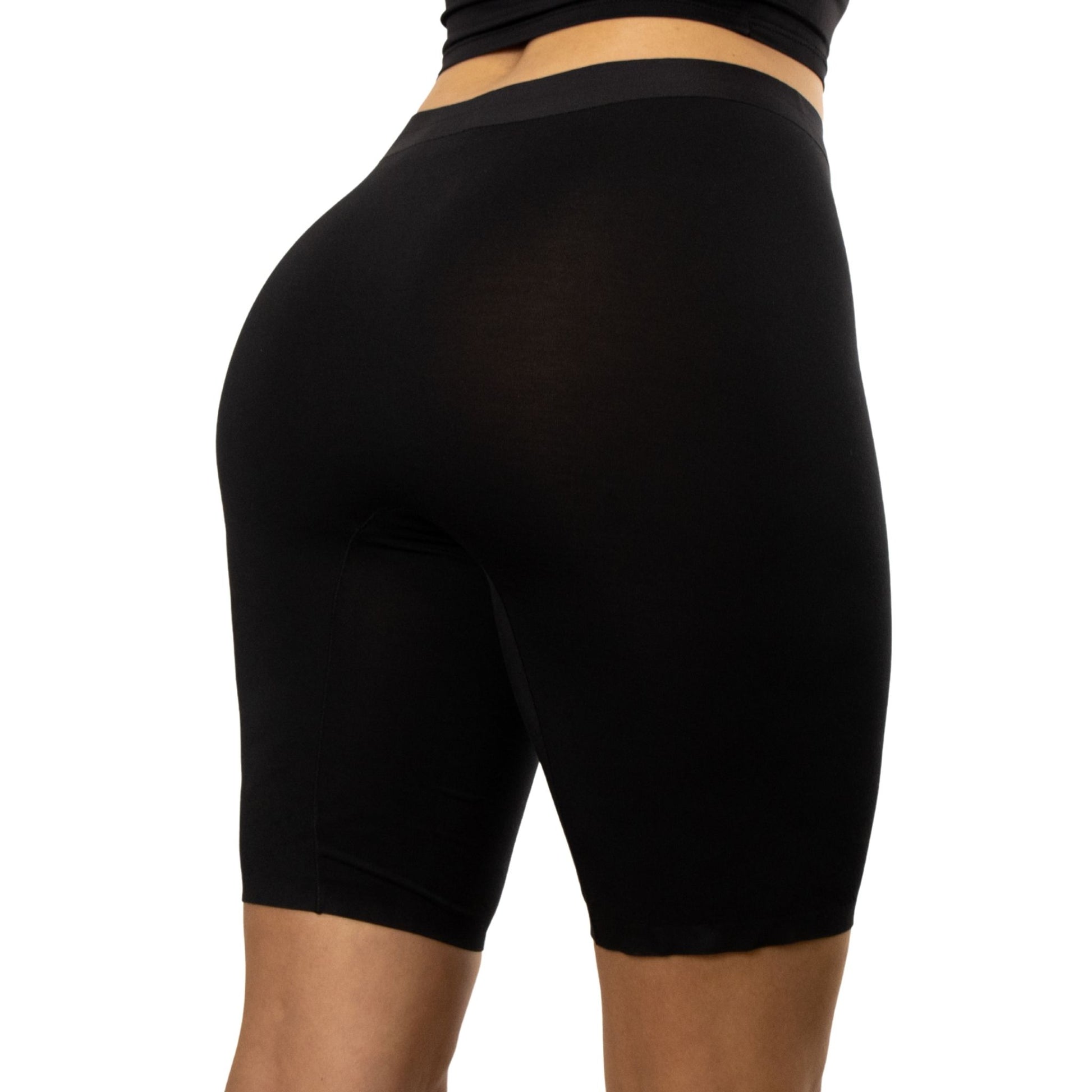 A close-up view of a person wearing PureSnug's black high-waisted biker shorts,.