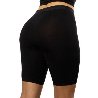 A close-up view of a person wearing PureSnug's black high-waisted biker shorts,.