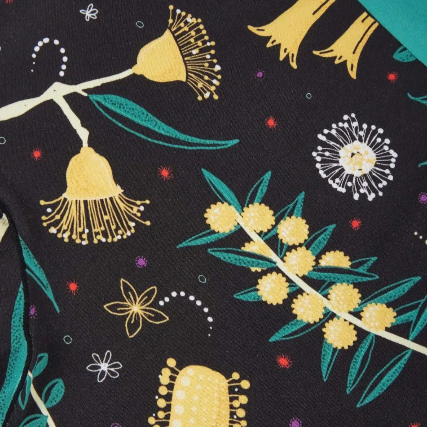Zoomed-in view of PureSnug black fabric adorned with striking floral designs in yellow, green, and colorful accent tones.