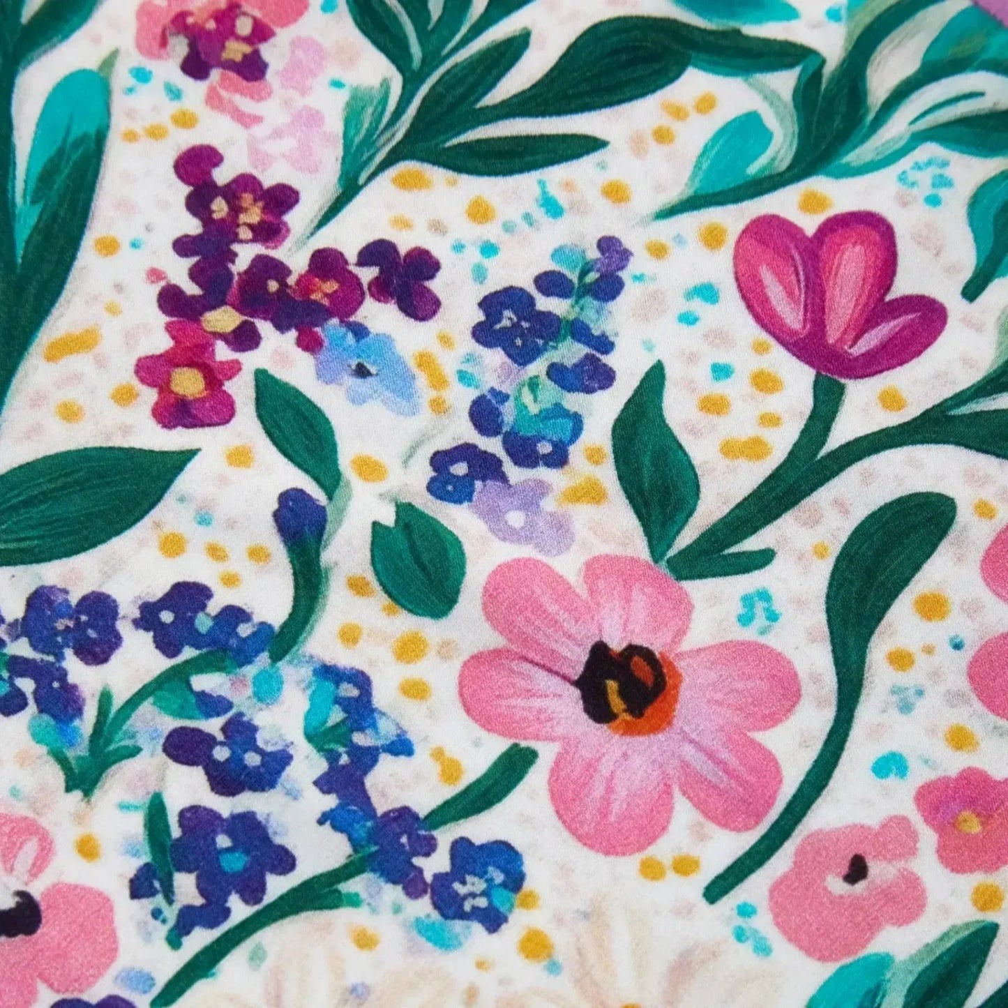 Colorful floral pattern of PureSnug Meadow Muse featuring various flowers in pink, purple, and blue hues with green leaves