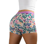 Back view of person wearing Meadow Muse floral-patterned PureSnug boyshort underwear with purple waistband