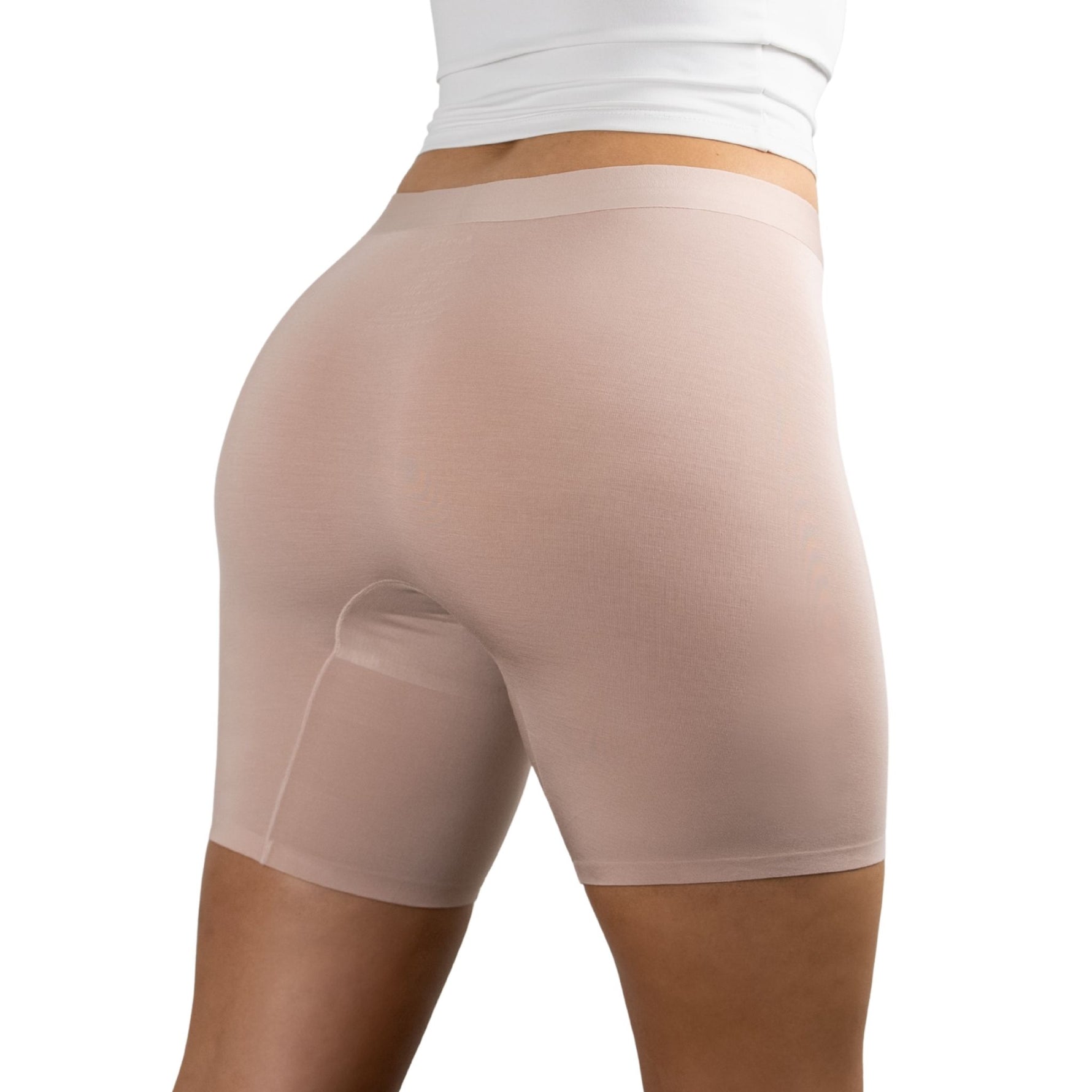 Back view of person wearing seamless Blush Beige nude-colored PureSnug women boxer shorts with white top