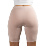 Back view of a woman wearing PureSnug's High-waisted Blush Beige nude-colored seamless biker shorts and a white top.