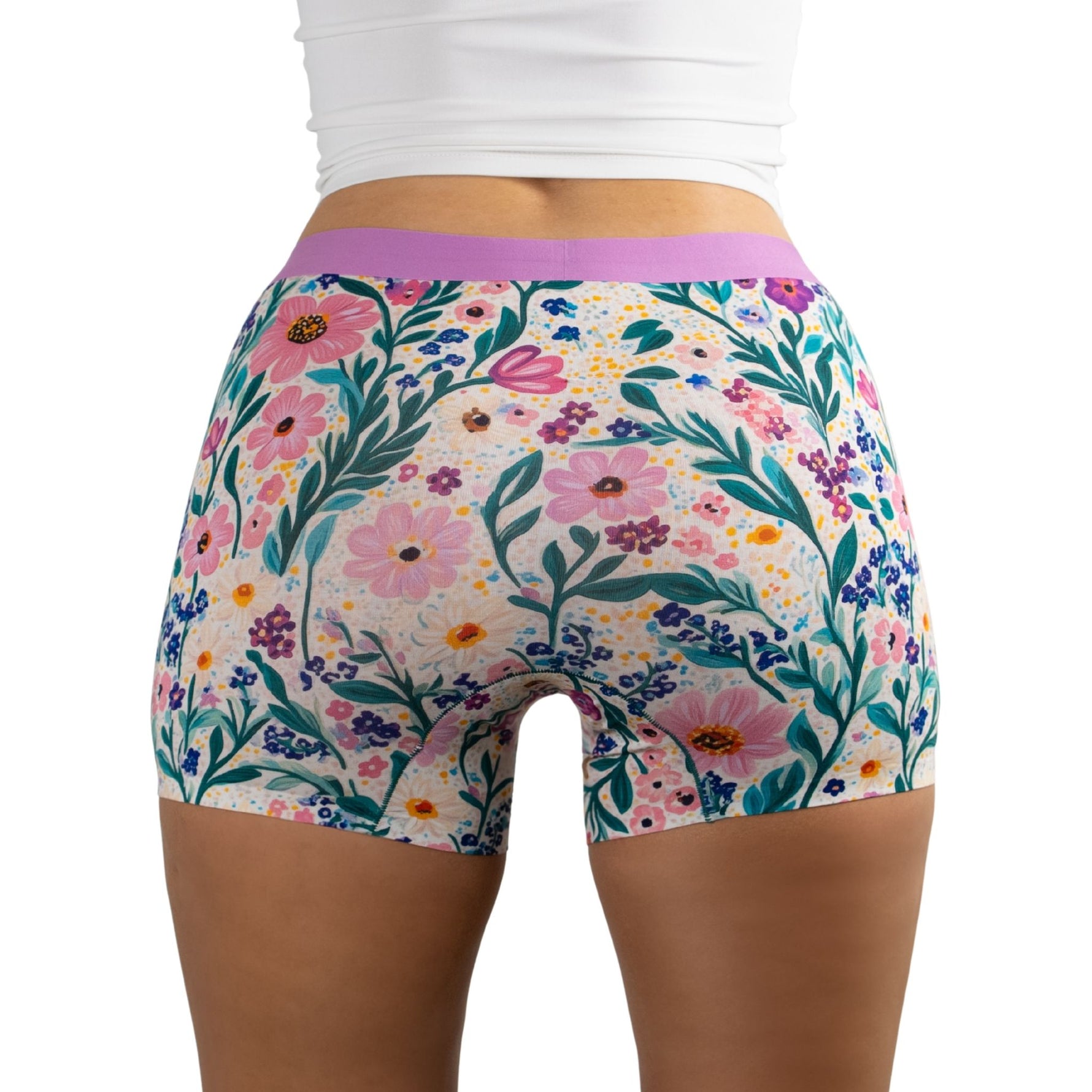 Back view of person wearing floral-patterned PureSnug boyshorts with vibrant pink, purple, orange flowers and green leaves