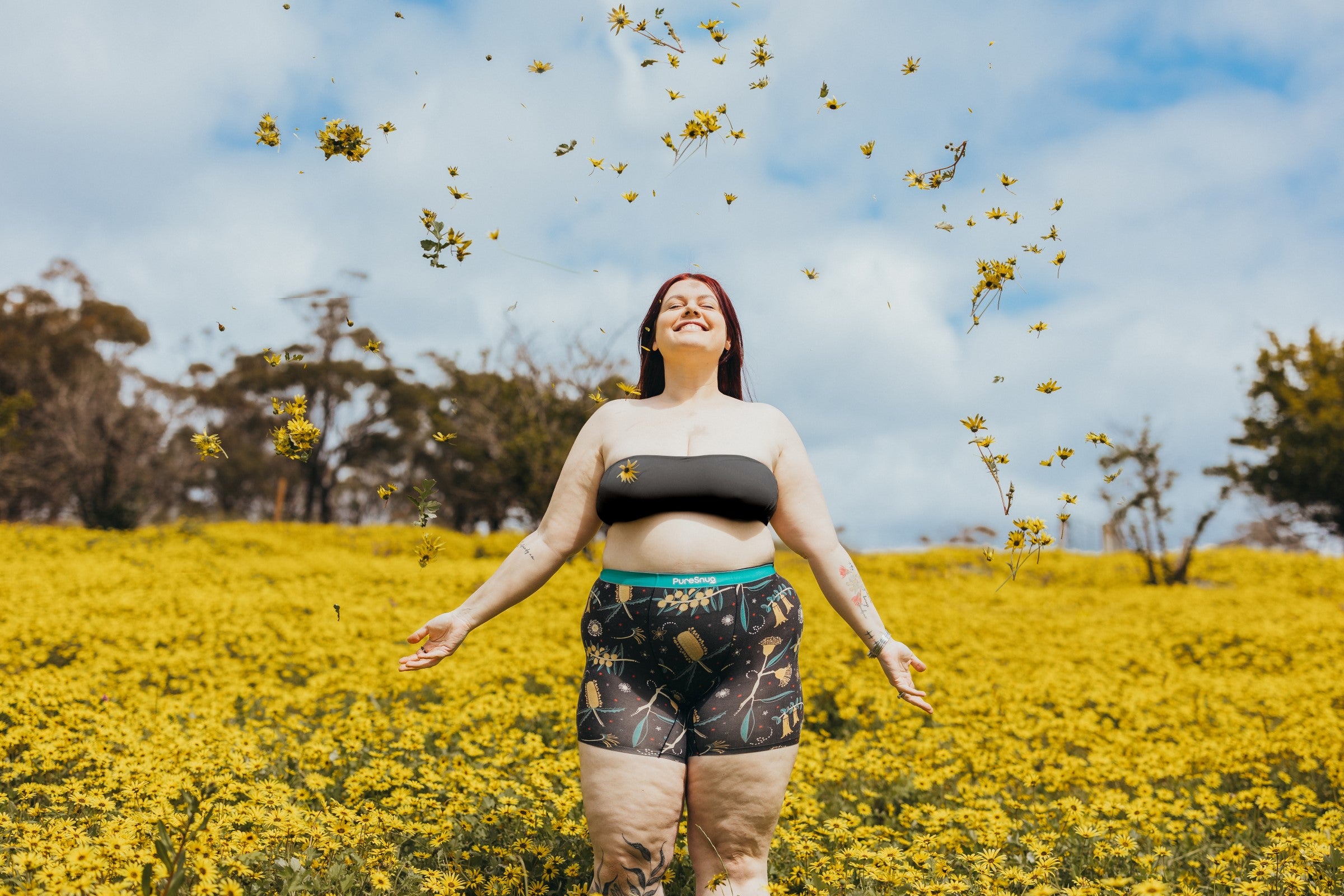 Woman standing in a field of yellow flowers with a blue sky in Pure Snug boxer briefs
